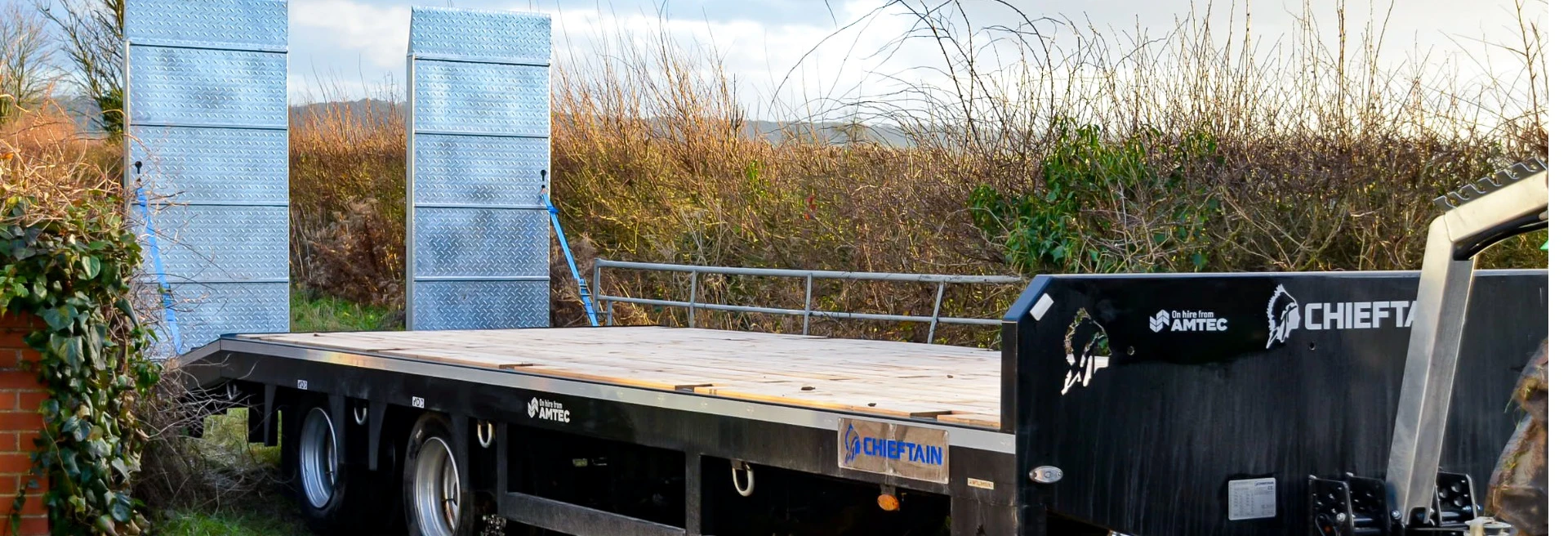 Flatbed trailer coming out of a farm entrance in Warwickshire