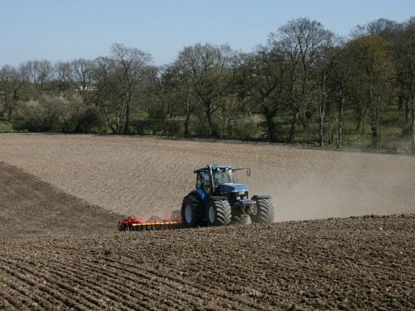 Vaderstad TopDown being pulled by a blue tractor as it cultivates undulating stubble fields